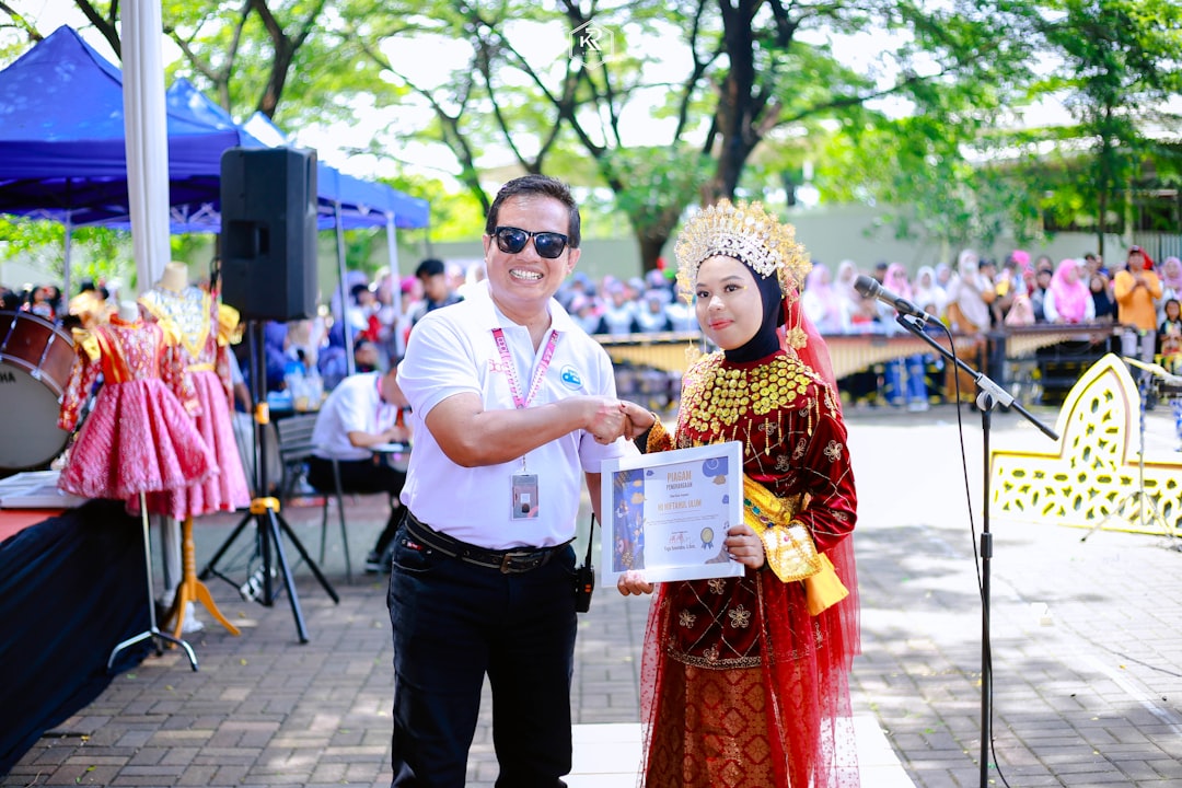 Man and woman in traditional attire shaking hands