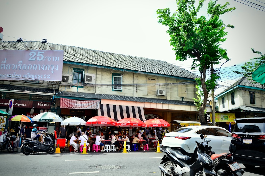 Street scene with vendors and shoppers under umbrellas