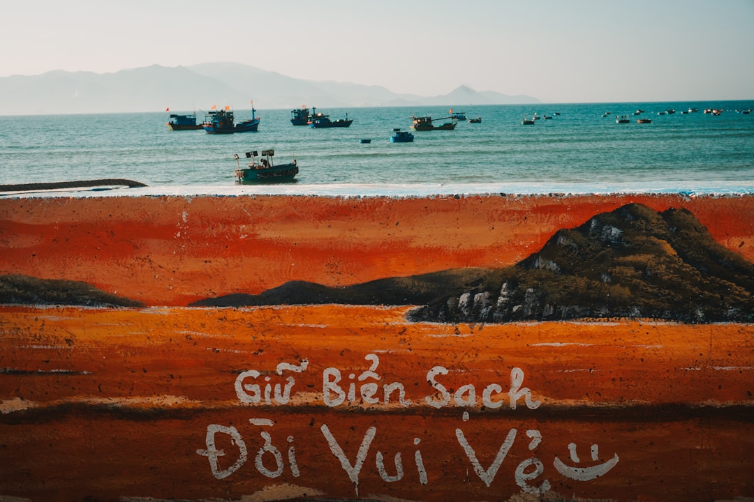 Boats on the ocean beyond a painted beach mural