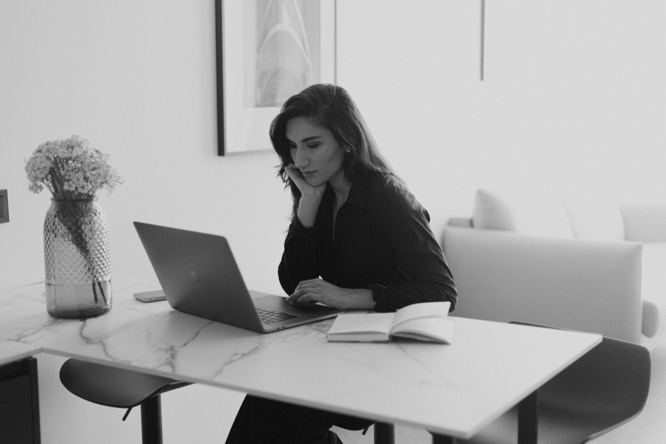 Woman working on a laptop in a modern office, engaging in focused work.