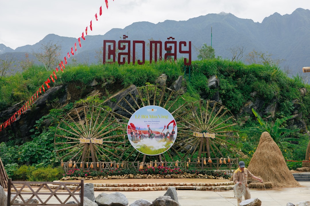 A man standing in front of a sign with a mountain in the background