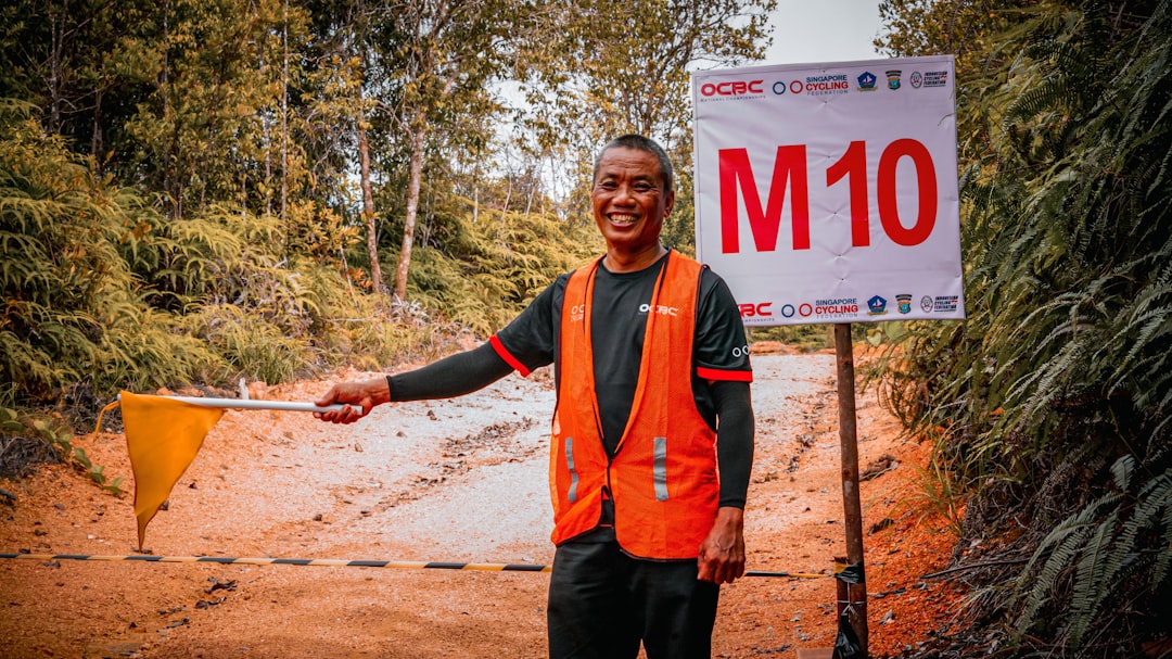A smiling man is posing with a race sign.